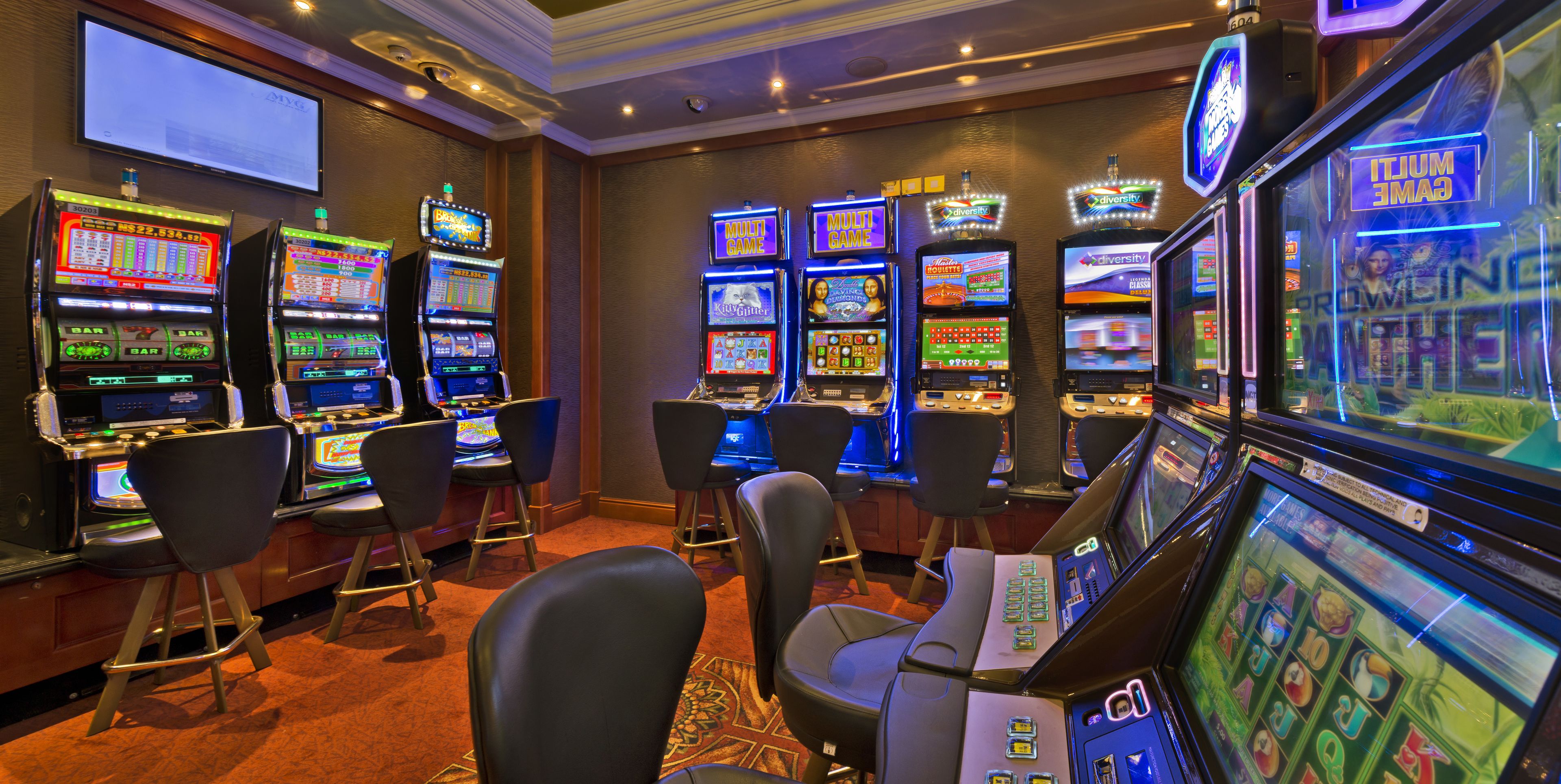 Un casino con múltiples máquinas tragamonedas y zonas de bar.