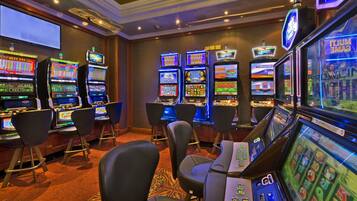 Un casino con múltiples máquinas tragamonedas y zonas de bar.