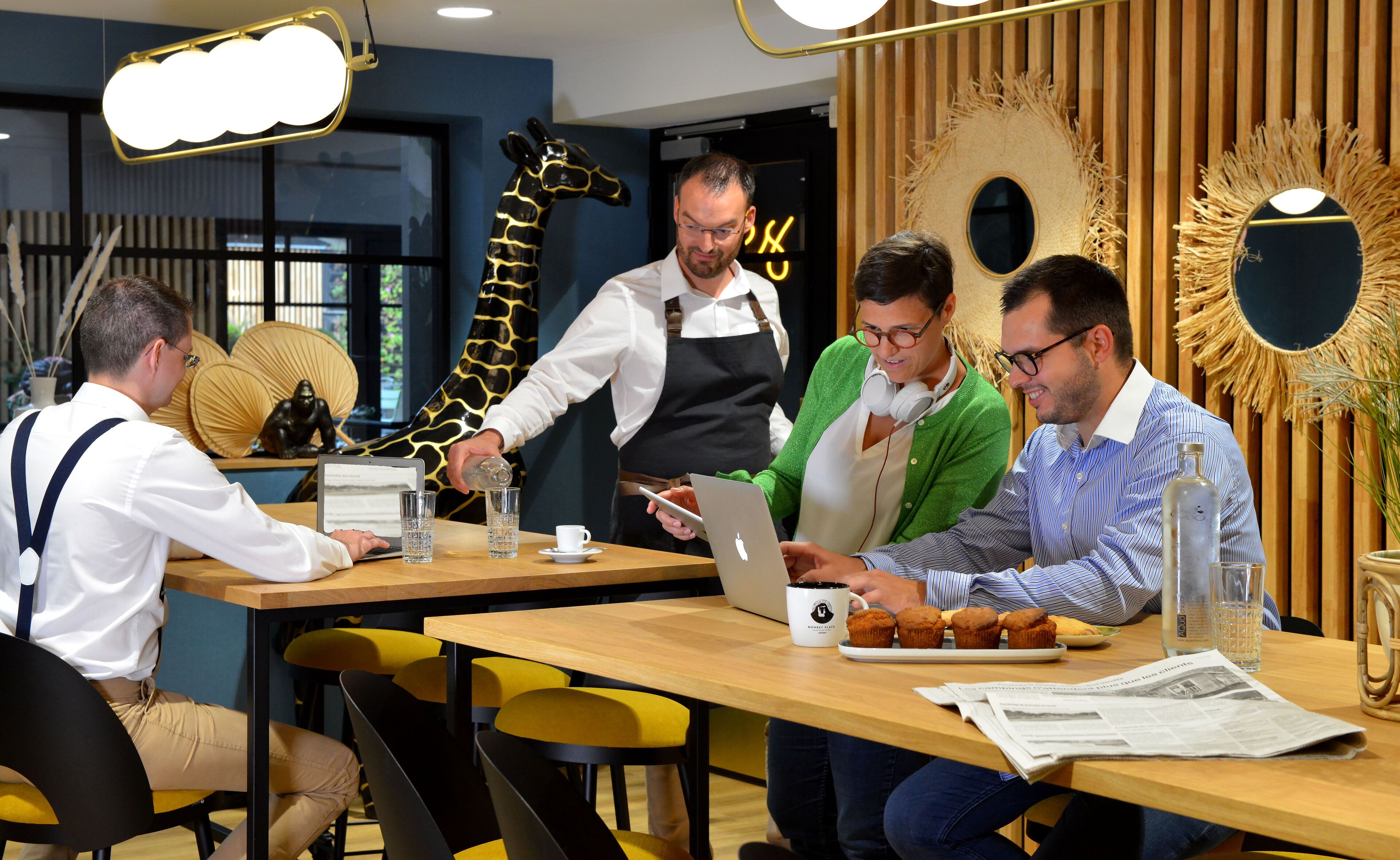 A modern dining area with wooden tables, yellow chairs, and a giraffe decoration.