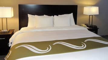 Habitación de hotel con una cama grande, dos mesitas de noche y una lámpara a cada lado.