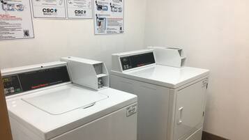 Two front-loading commercial washers with digital displays, labeled 'CSC ServiceWorks'.