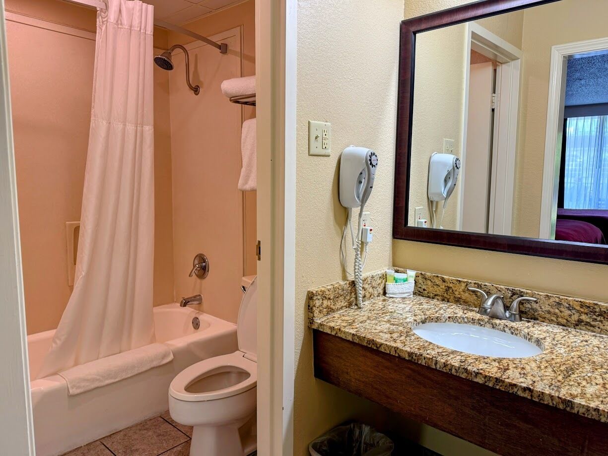A bathroom with a bathtub, toilet, and sink.
