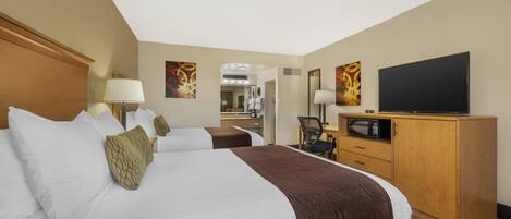 Une chambre d’hôtel avec un grand lit, un bureau avec une chaise, une télévision et un four à micro-ondes.