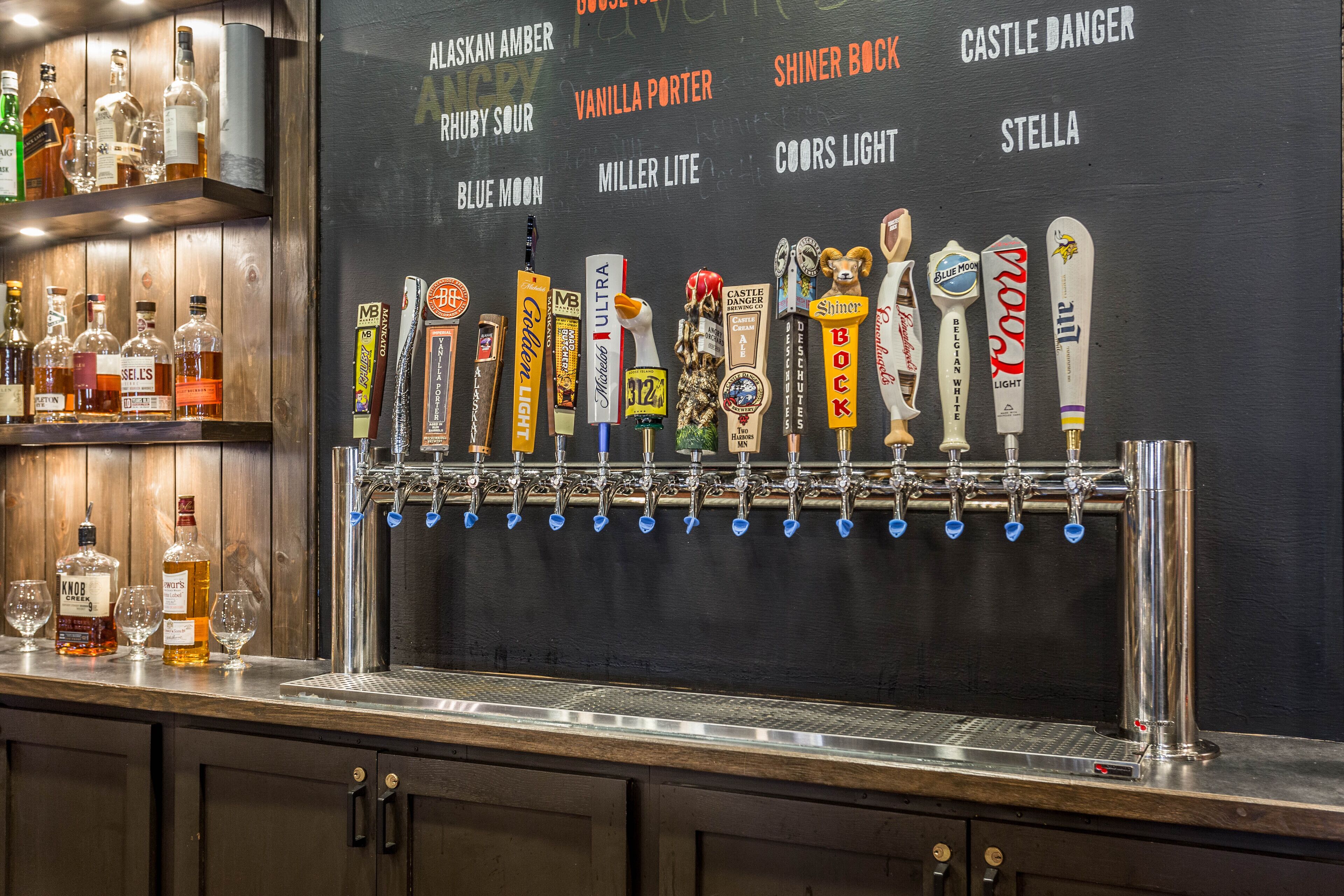 A bar with a tap system labeled with various beer brands.