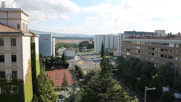 Un paisaje urbano con edificios, una cancha de tenis y un cielo despejado.