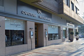 Um edifício com uma placa indicando 'CAFETERIA RESTAURANTE' e 'Hotel'.