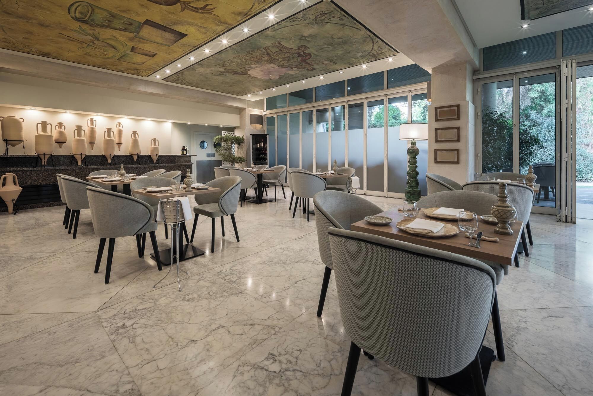 A spacious dining area with marble flooring, modern chairs, and a ceiling mural.