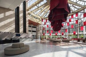 A spacious atrium with a high ceiling, large windows, and a central seating area. - Eurostars Al-Ándalus Palace (Seville)