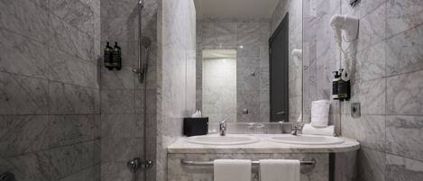 Une salle de bain moderne avec un sol en marbre, une baignoire, un lavabo avec un meuble-vasque et un miroir.
