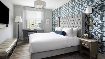 Ein modernes Hotelzimmer mit einem großen Bett, einem Schreibtisch und Blick auf die Stadt durch das Fenster.