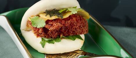A food item on a green plate with a white and gold design.