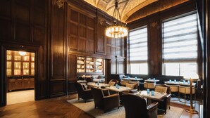 A spacious library with wooden bookshelves, comfortable seating, and large windows allowing natural light. - Beacon Grand, A Union Square Hotel  (San Francisco)