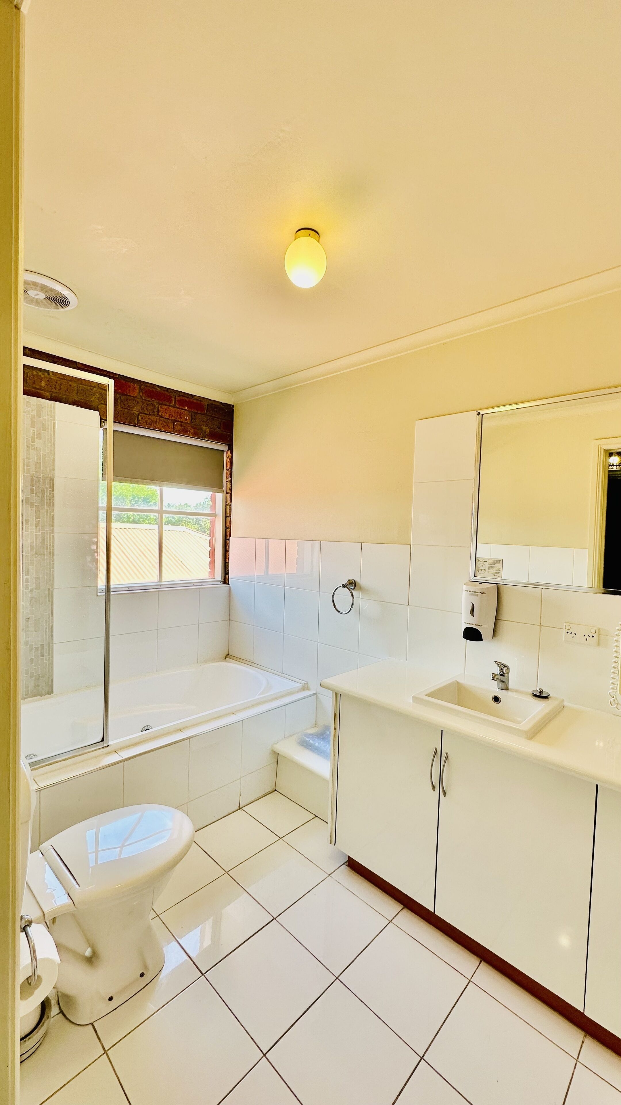 A bathroom with a toilet, sink, and bathtub.