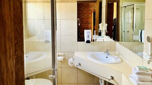 A modern bathroom with two sinks, a glass shower enclosure, and a large mirror. - Early Australian Motor Inn (Mildura)
