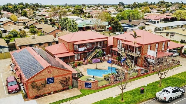 A two-story motel with a swimming pool, outdoor seating, and a parking area. - Early Australian Motor Inn (Mildura)
