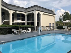 Piscine extérieure en saison, parasols, chaises longues