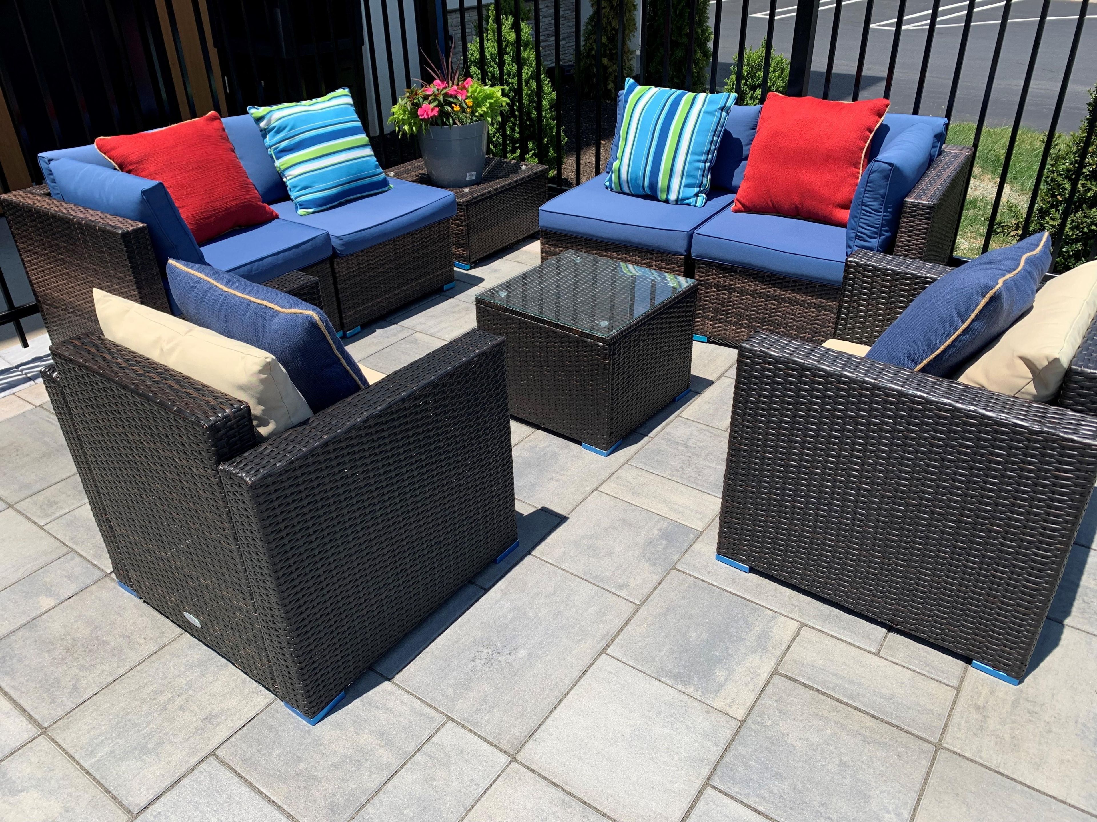A patio area with wicker furniture, including sofas and chairs, and a central coffee table.