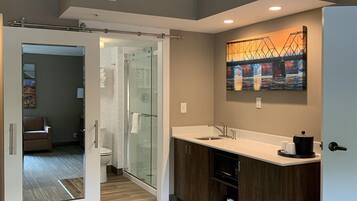 A modern bathroom with a glass shower enclosure, a toilet, and a sink with a countertop.