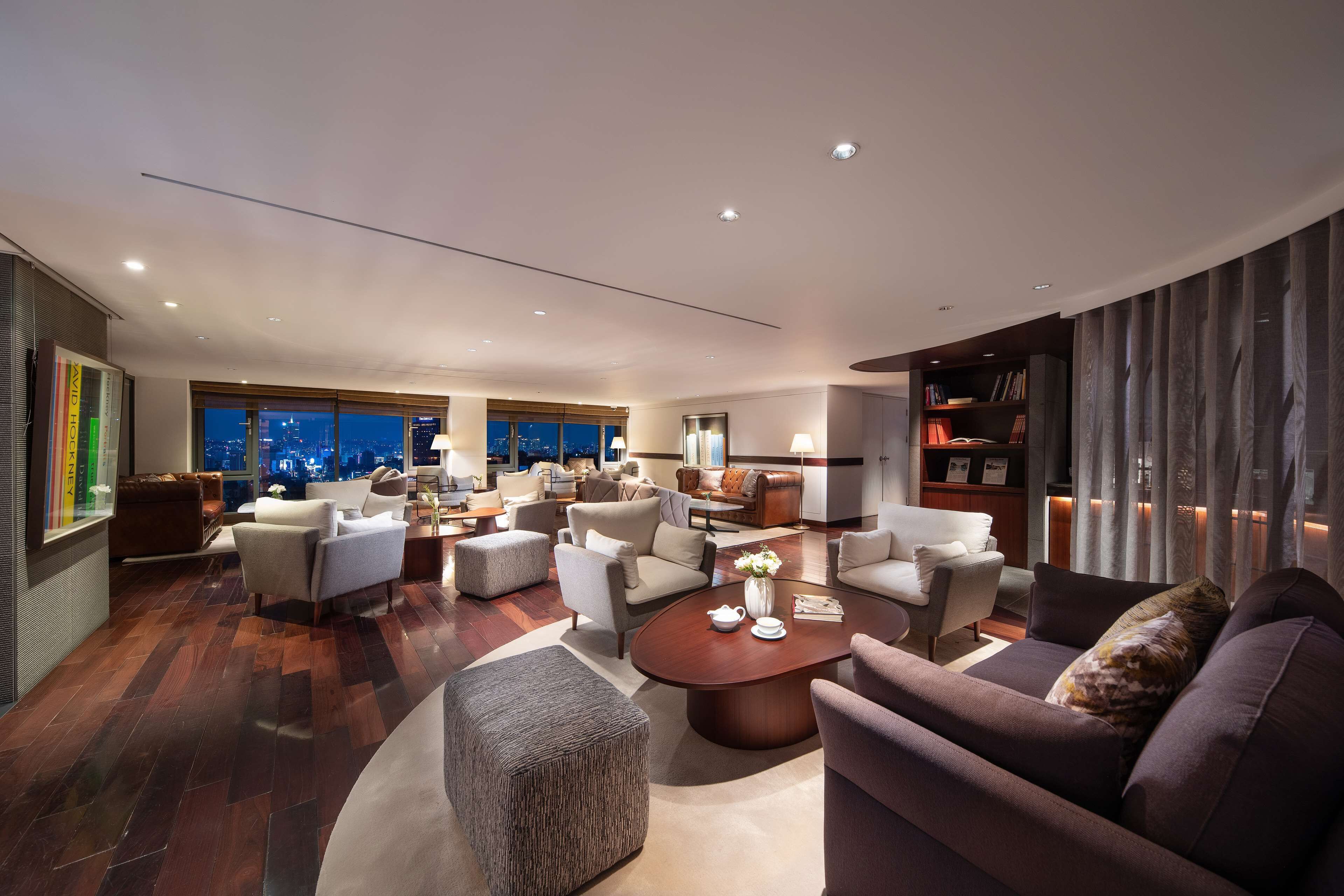 A spacious living area with multiple seating options, a coffee table, and a bookshelf.