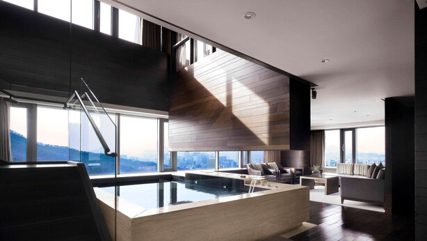 A modern interior with a large glass window, a wooden ceiling, and a central pool area. - BanyanTree Club & Spa Seoul (Seoul)