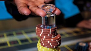Eine Hand hält einen Stapel Pokerchips in verschiedenen Farben.
