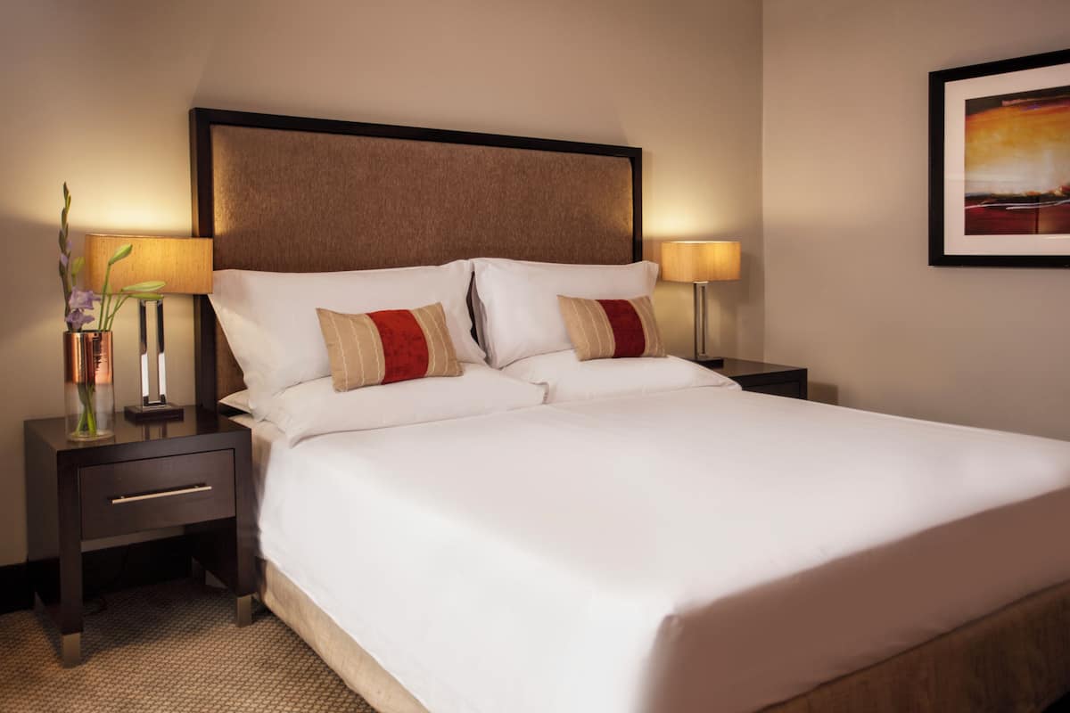 Relax in a serene space with a large bed, two nightstands, and a framed picture on the wall.