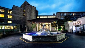 A hotel entrance with a fountain, stone architecture, and a casino sign. - Avani Lesotho Hotel & Casino (Maseru)