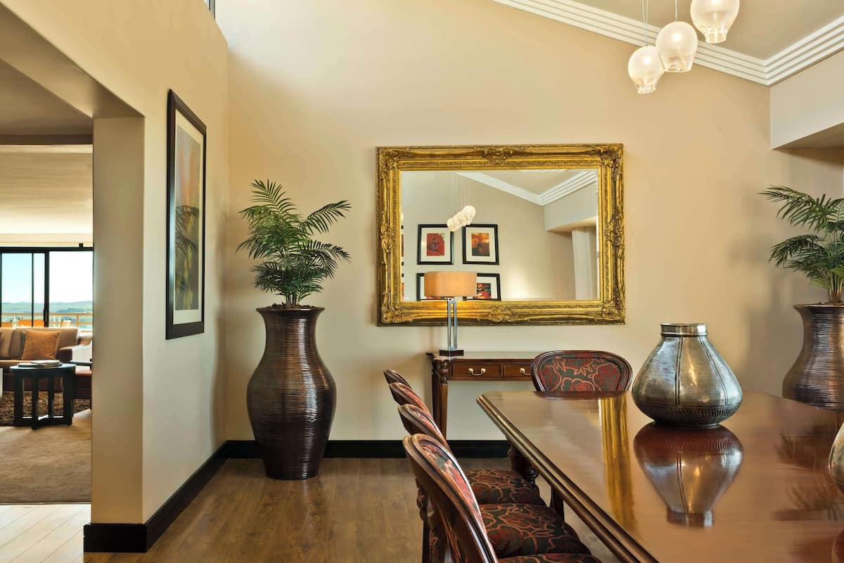 Enjoy ocean views reflected in the ornate mirror, surrounded by lush greenery and elegant artwork.