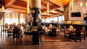 A restaurant with wooden ceilings and a central bar area. - Avani Lesotho Hotel & Casino (Maseru)
