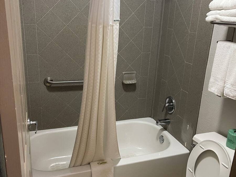 A bathroom with a bathtub, shower, and toilet.