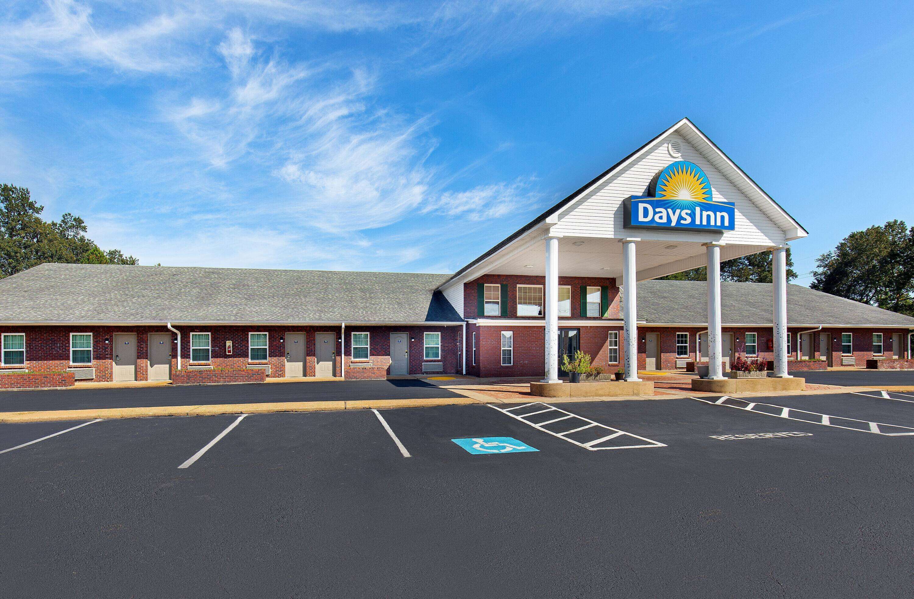 A Days Inn with a covered entrance, a parking lot with handicapped parking, and a brick building facade.