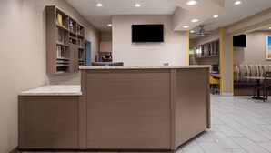 A modern kitchen with built-in cabinets, a countertop, and a flat-screen TV mounted above the counter. - Days Inn & Suites by Wyndham Airport Albuquerque (Albuquerque)