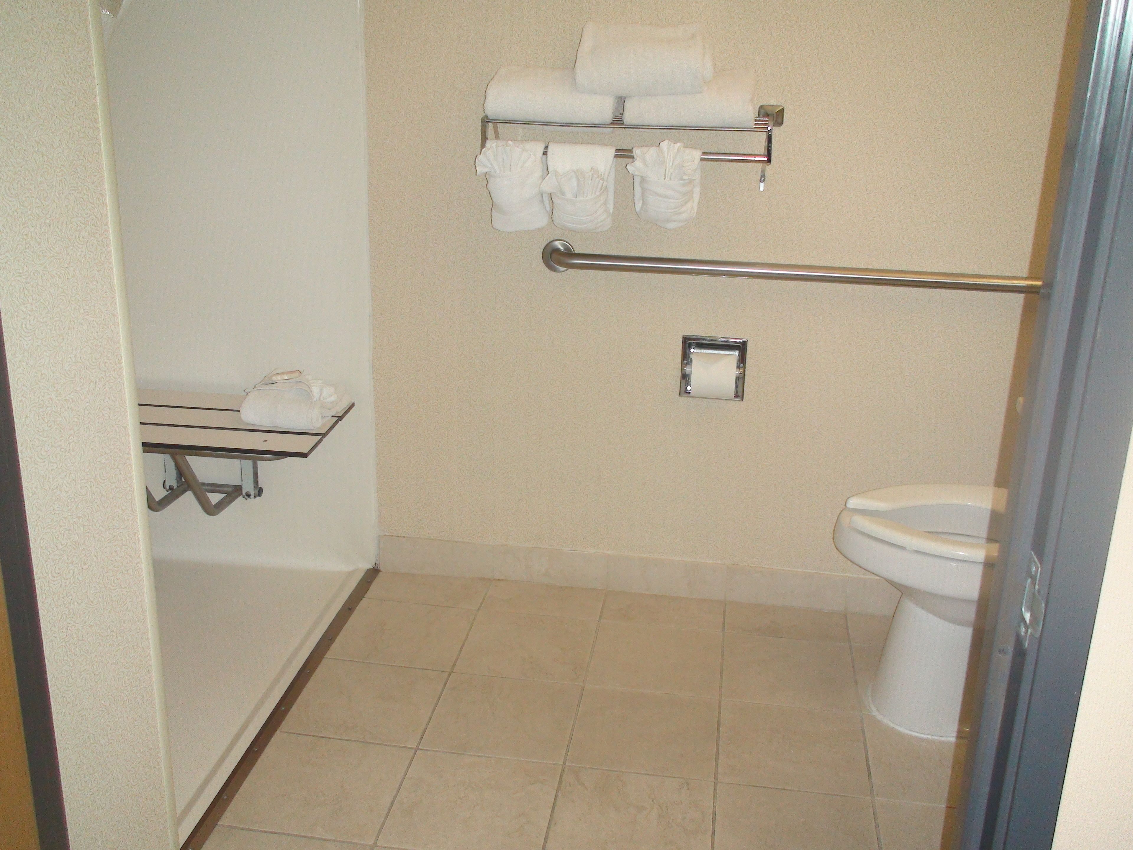 Une petite salle de bain comprenant des toilettes, un porte-serviettes et un sèche-mains.