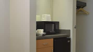 A compact kitchen with a microwave, coffee maker, and a small refrigerator.