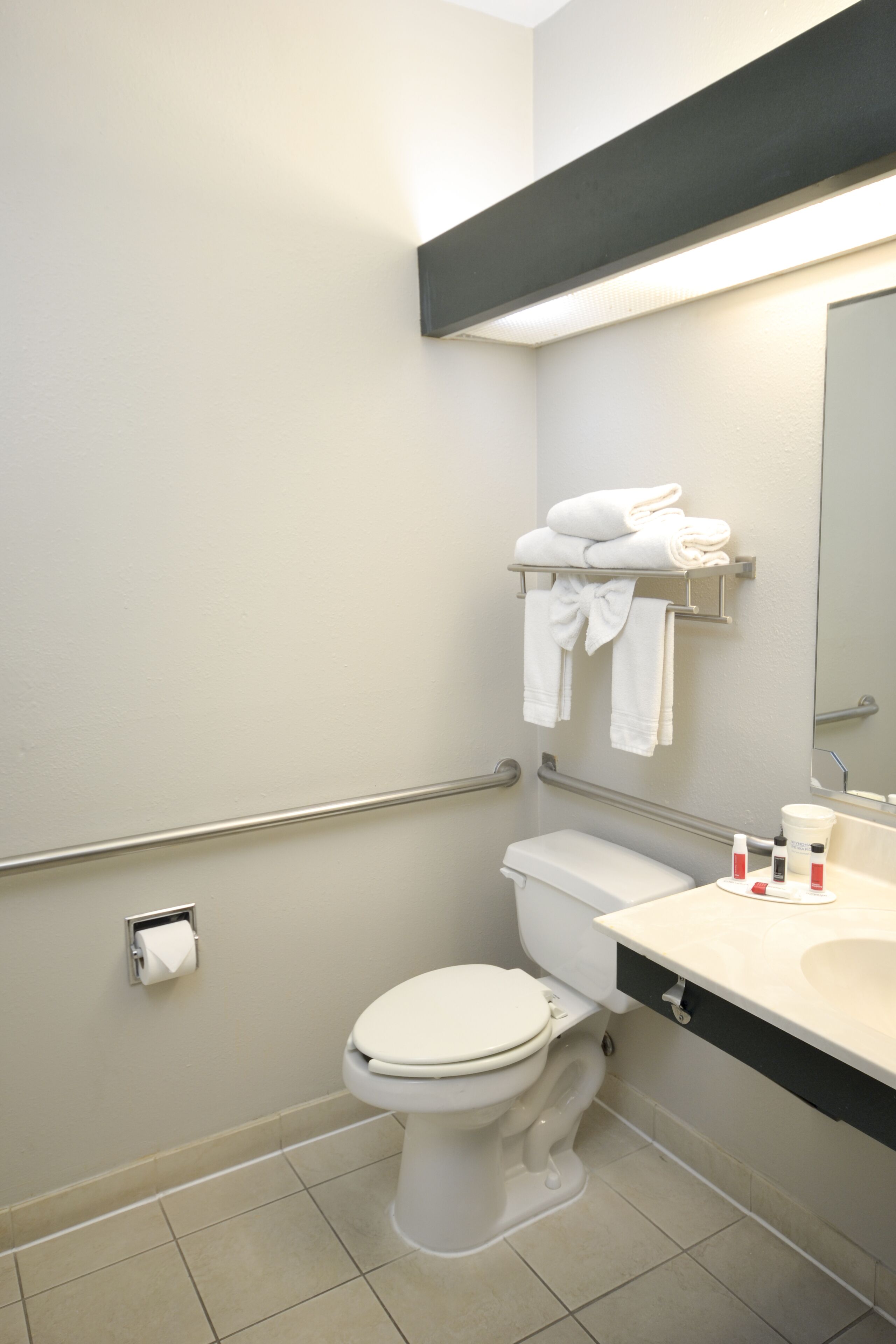 A modern bathroom with a toilet, sink, and towel rack.