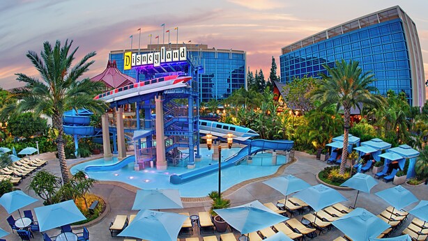 A water park area with a water slide, pool, and lounge chairs. - Disneyland Hotel (Anaheim)