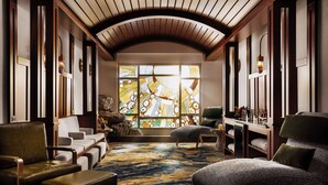 A room with a large stained glass window, leather sofas, and a patterned carpet. - Disneyland Hotel (Anaheim)