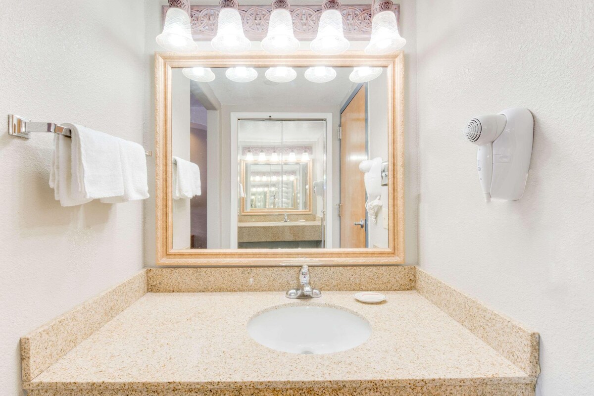 A bathroom with a sink, mirror, towel rack, and hair dryer.