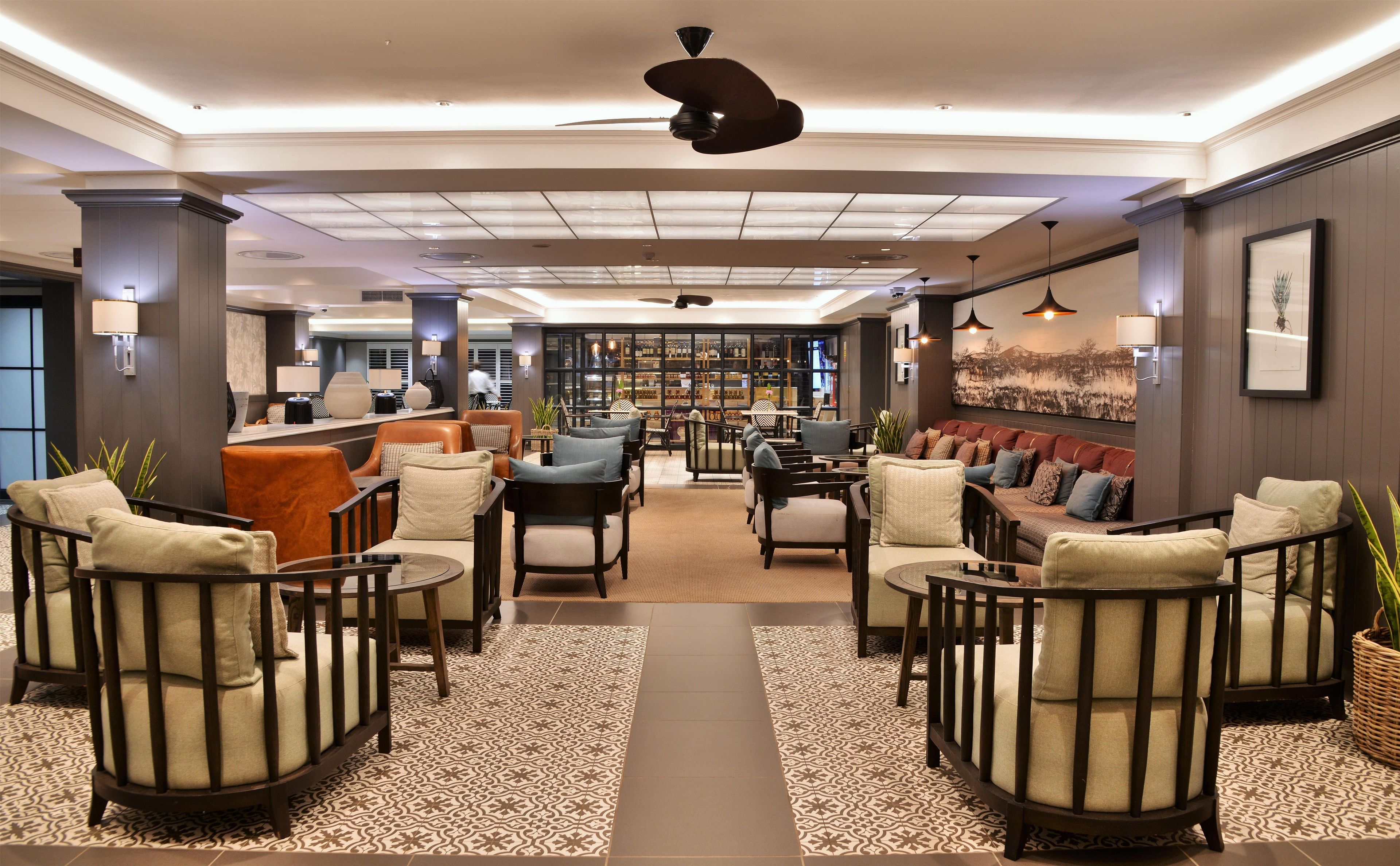 Un vestíbulo de hotel con zona de estar, un bar y una estantería.