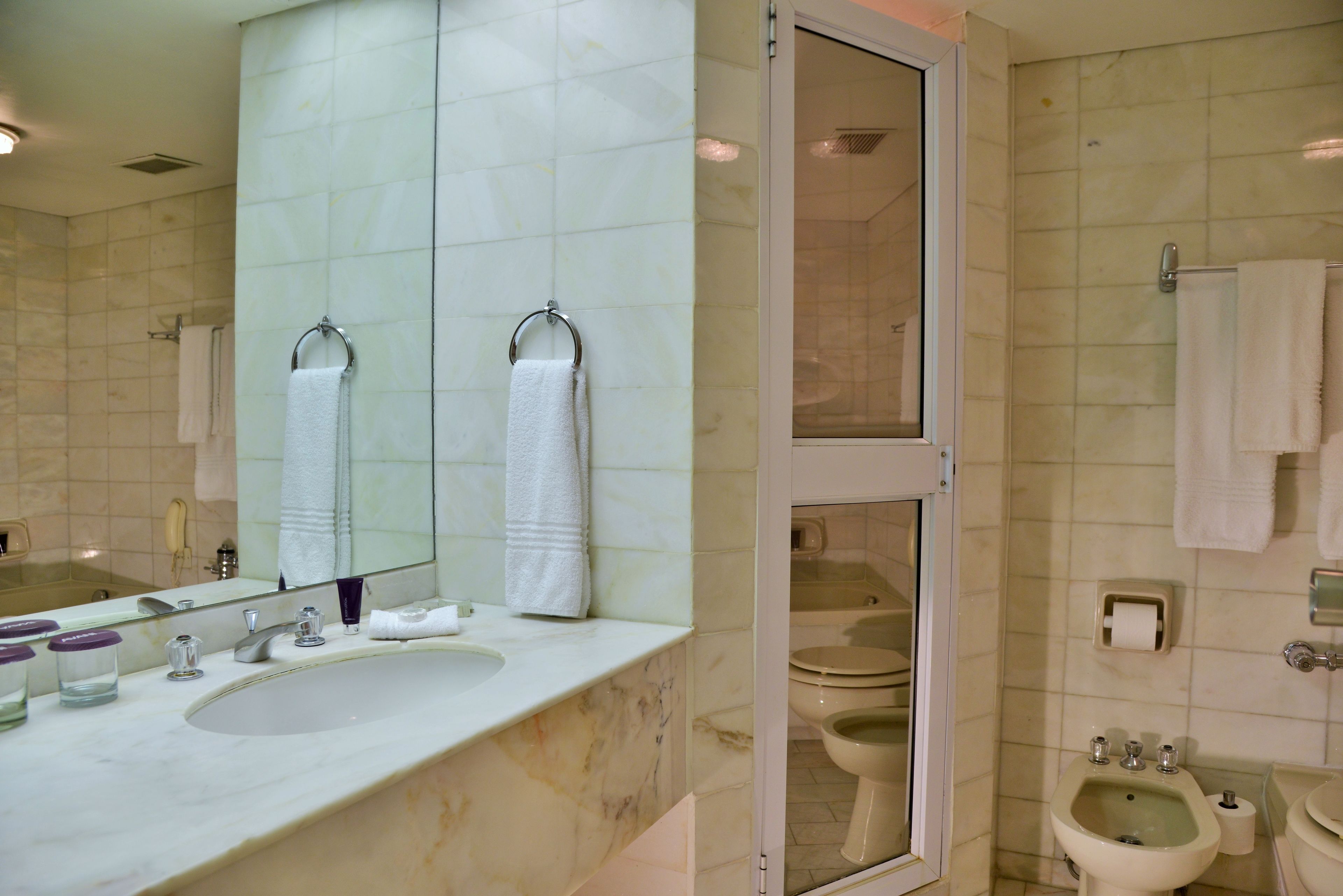 Un bagno con lavandino, specchio e due servizi igienici.