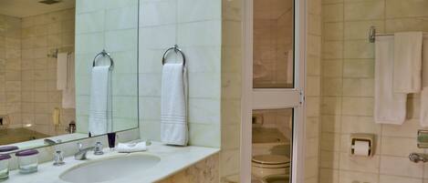 Un bagno con lavandino, specchio e due servizi igienici.