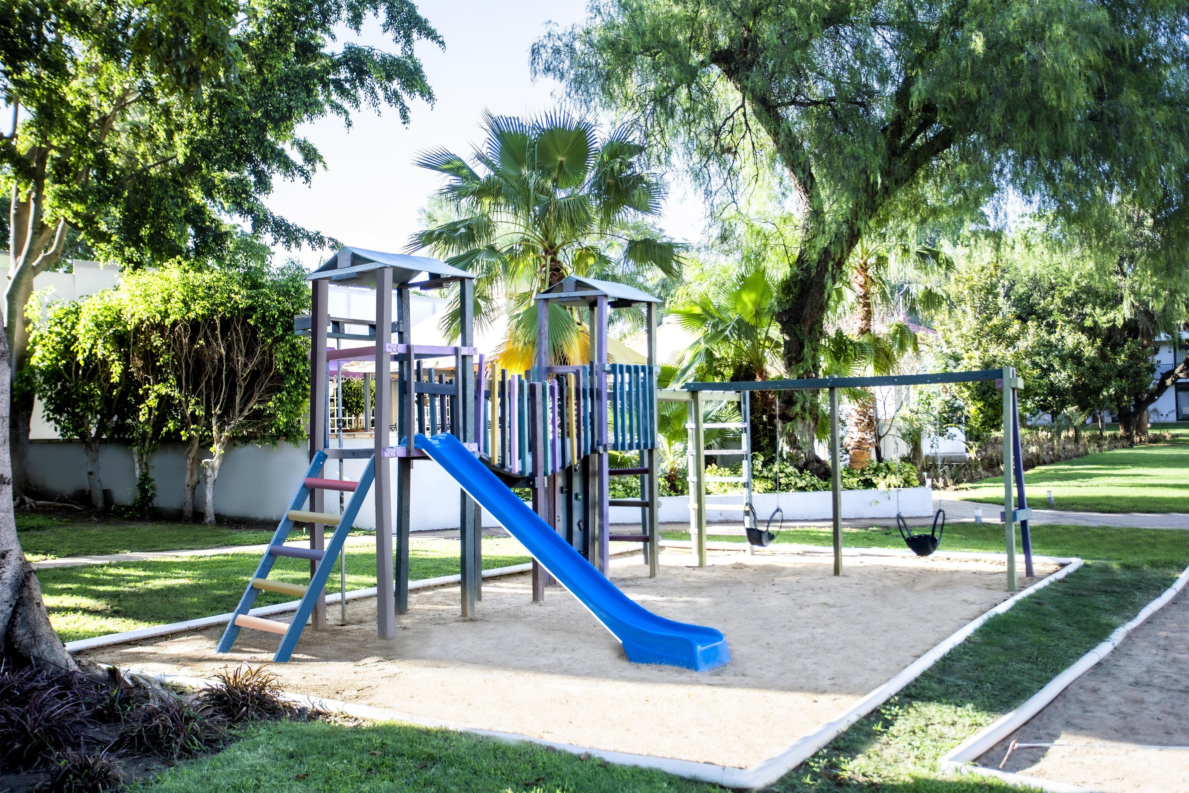 A playground with a slide, swings, and a climbing structure.