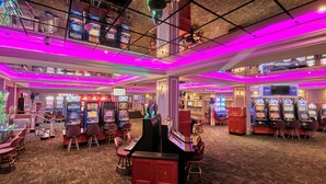 A casino interior with multiple gaming machines, chairs, and a bar area. - Avani Gaborone Resort & Casino (Gaborone)