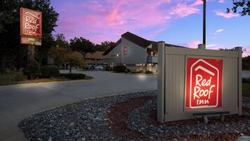 A Red Roof Inn with a clear sky and a sunset.
