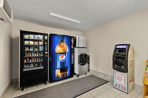 Una habitación con máquinas expendedoras, un refrigerador y un cajero automático.