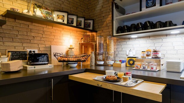 A kitchenette with a coffee machine, microwave, and various food items on the counter. - B&B Hotel Reims Centre Erlon (Reims)