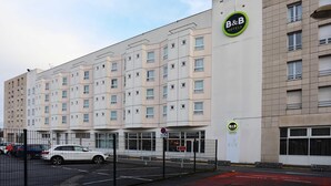 A B&B hotel with a modern facade, multiple windows, and a gated entrance.