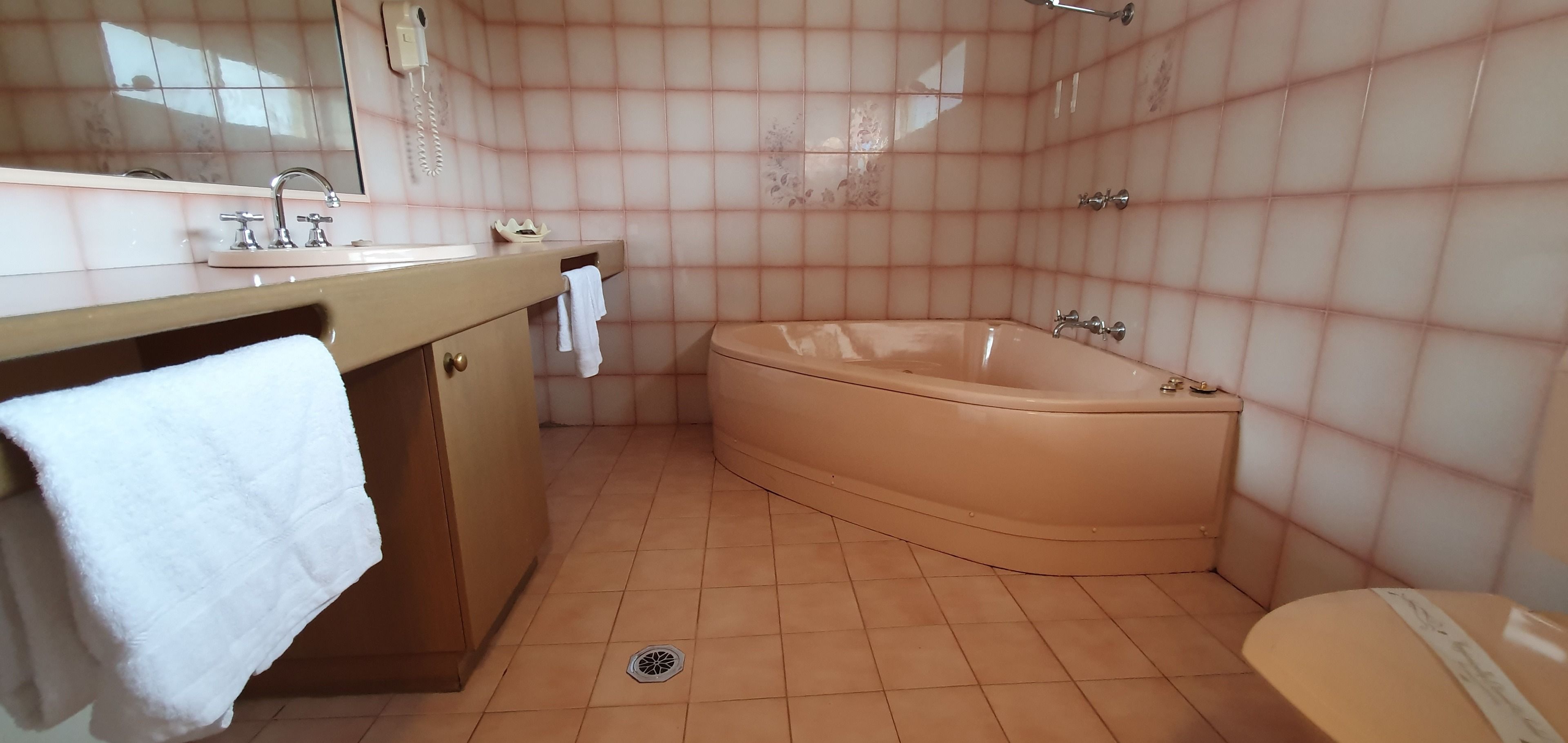 A bathroom with a bathtub, a sink with a mirror, and a toilet.