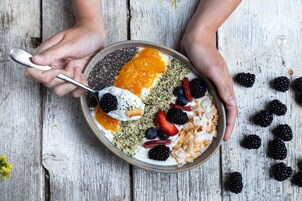 Un tazón de comida con diversas frutas y semillas.