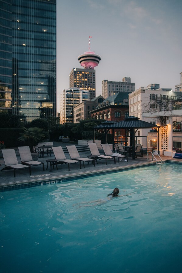 Una piscina al aire libre, una piscina climatizada, sombrillas, tumbonas